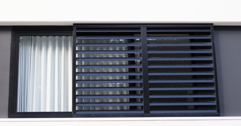 Multi story building window with metal louvres